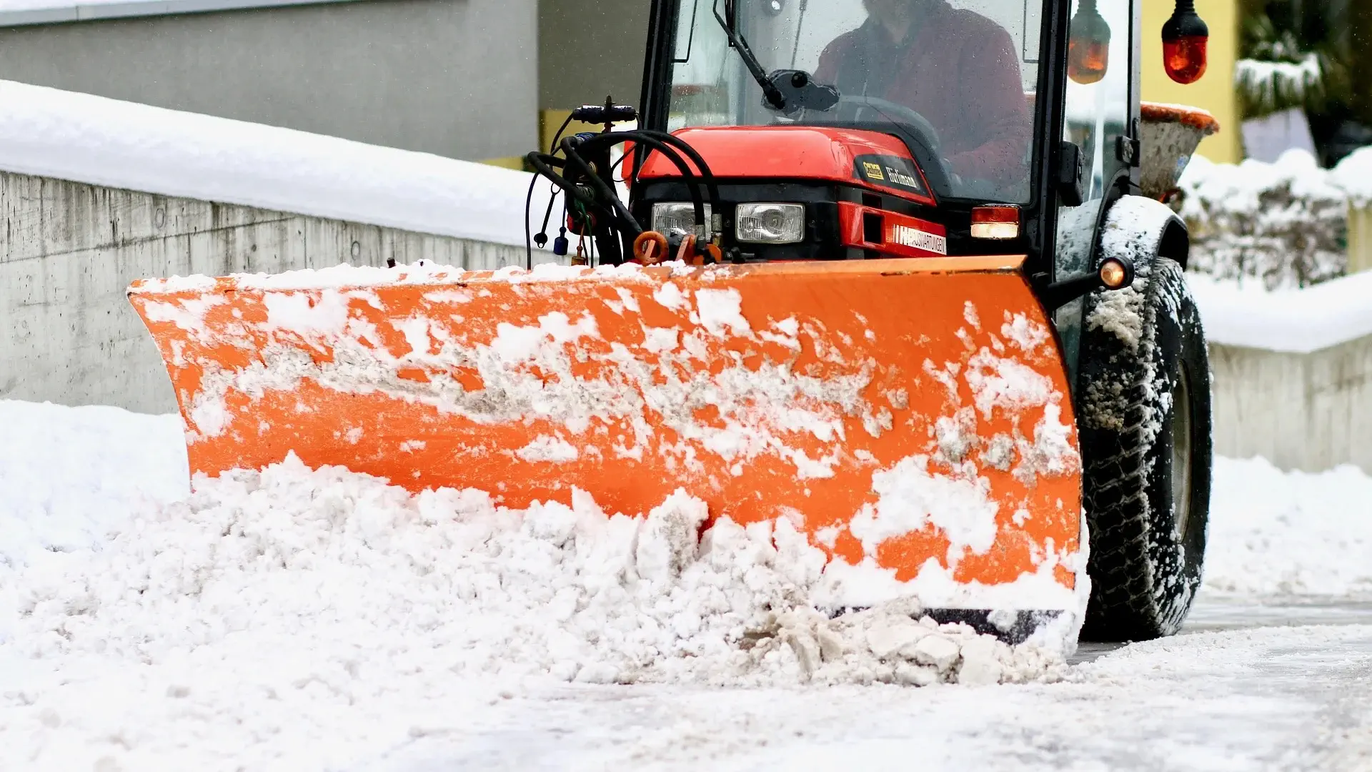 Tracteur de déneigement Services Sans Soucis dégageant une entrée résidentielle